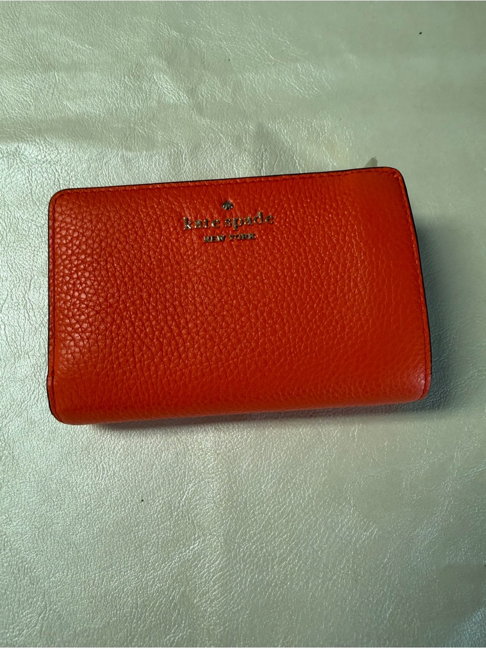 kate spade orange pebbled leather zip wallet with gold logo